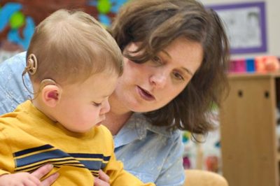Deaf education teacher working with student.